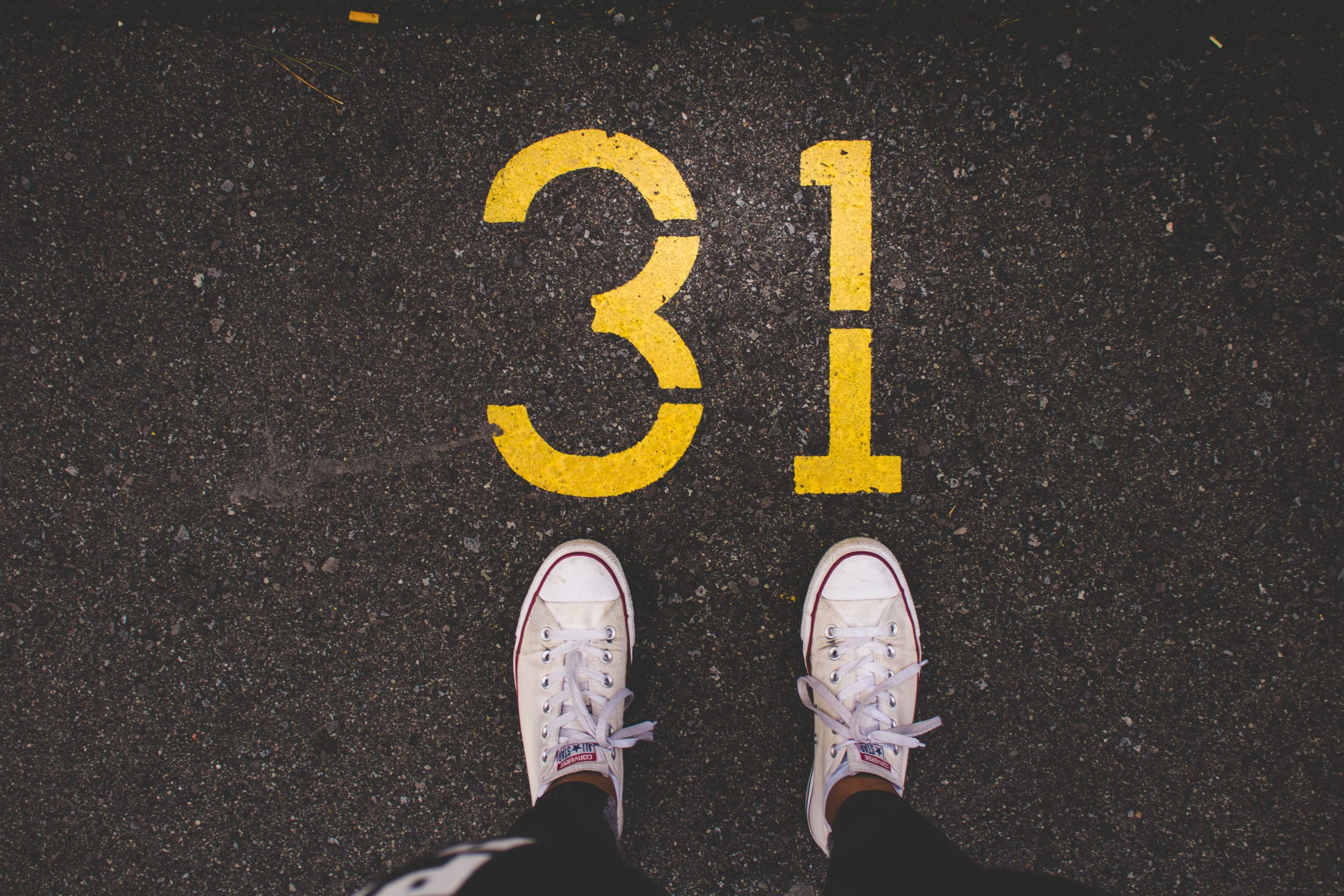 Pair of trainers in front of the number 31 painted on the road