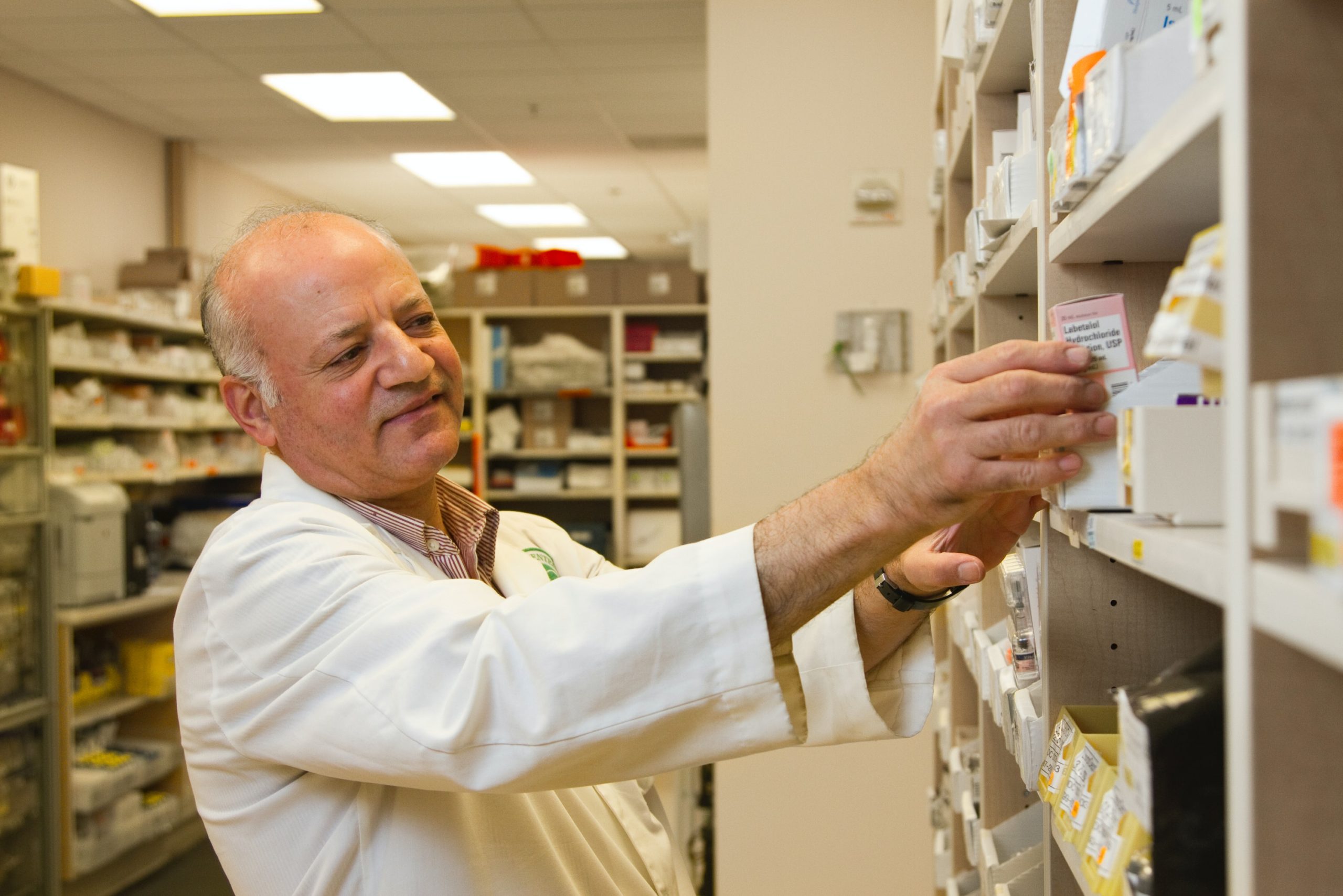 Image of man taking drugs from a shelf in the National Cancer Institute